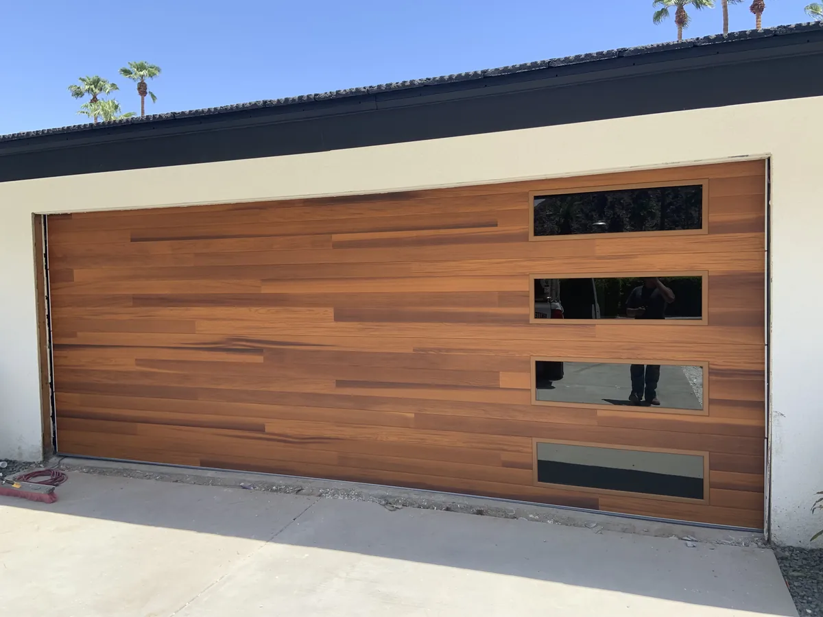Cedar tone wood garage door with staggered window slots