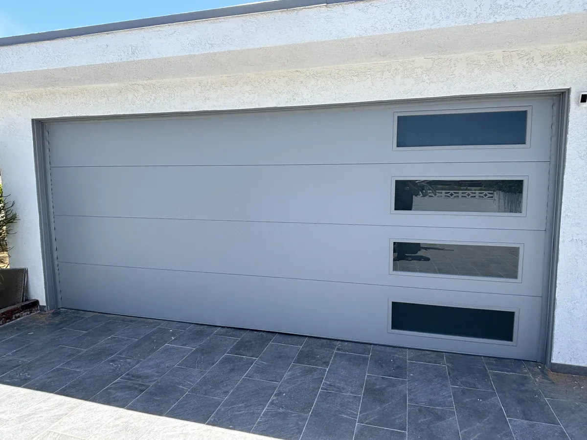 Light gray modern garage door with offset vertical window slots