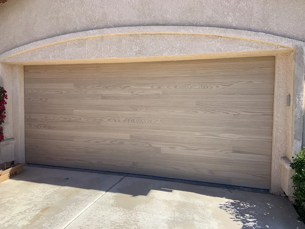 Tan flush garage door set into an arched opening