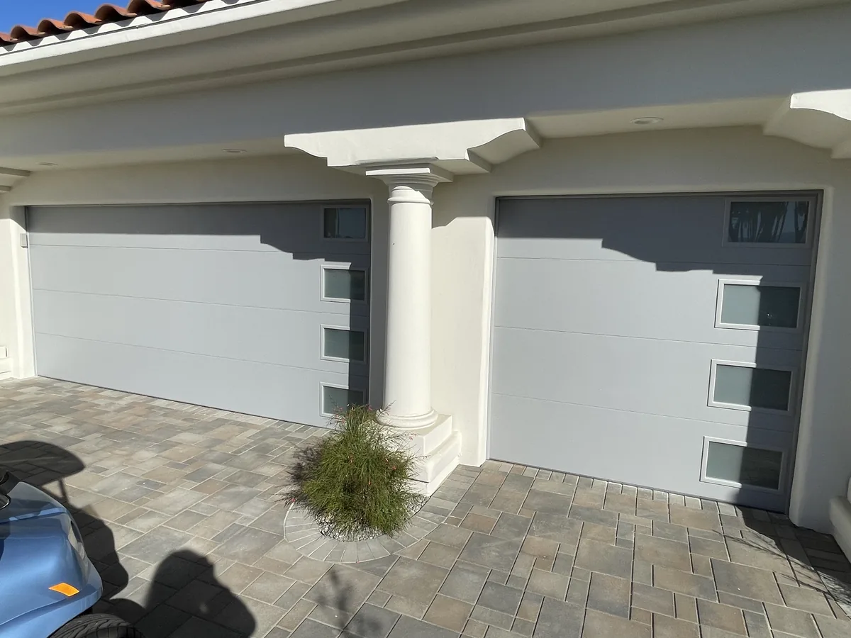 Two white modern garage doors with vertical window inserts